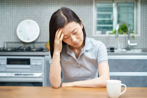 lady experiencing headaches in kitchen